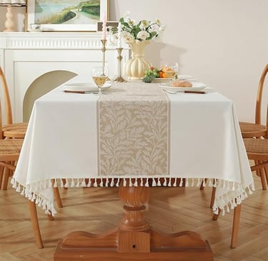 Neutral cotton-linen tablecloth with decorative tassel border, styled for a cosy rustic dining look.