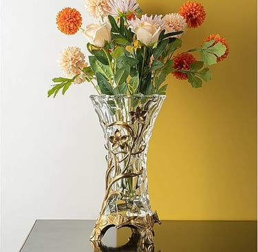 Ornate crystal vase with gold inlay patterns filled with fresh flowers, high-end decorative piece.