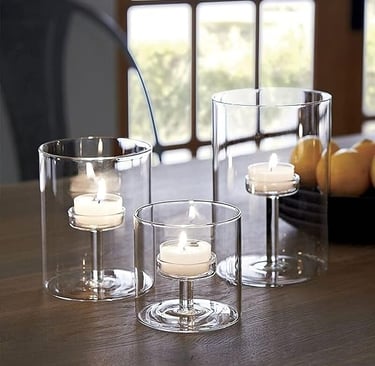 Tall hurricane tea light candle holders with white candles for cosy home décor.