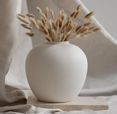 White textured ceramic vase with dried grass stems, minimal modern home décor.