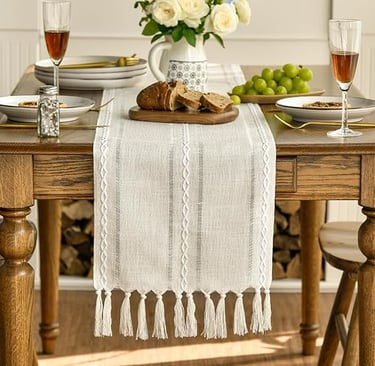 Cream boho table runner with long tassel edging, styled on a rustic wooden dining table.