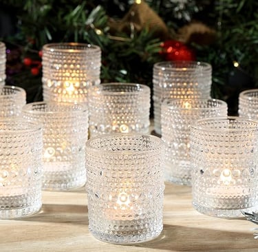 Set of clear ribbed drinking glasses arranged on a dining table in natural light.