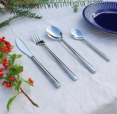 Stainless steel cutlery set placed on a fresh bright white tablescape.
