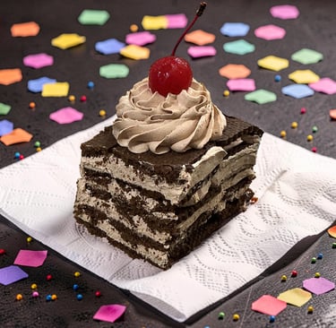 Un pastel de crema de chocolate en capas con una cereza de marrasquino encima, servido en una servil