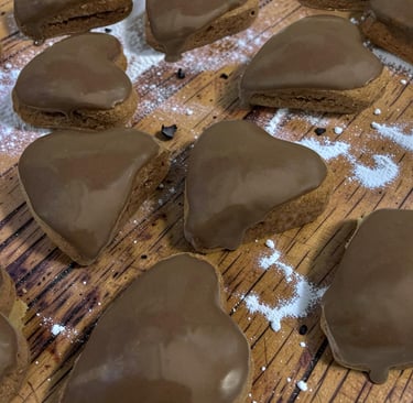 Galletas de jengibre en forma de corazón con glaseado de chocolate suave sobre una tabla de madera c