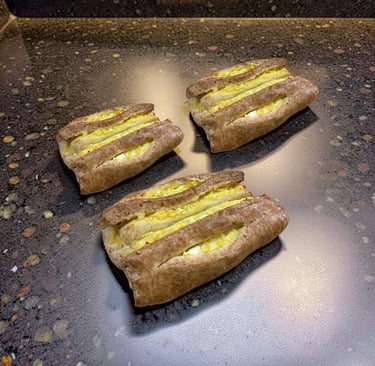 Tres pasteles karelianos finlandeses recién horneados con relleno de mantequilla de huevo sobre una 