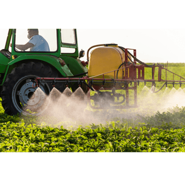 A green tractor with a yellow tank boom sprayer applying liquid fertilizer to a field of crops.