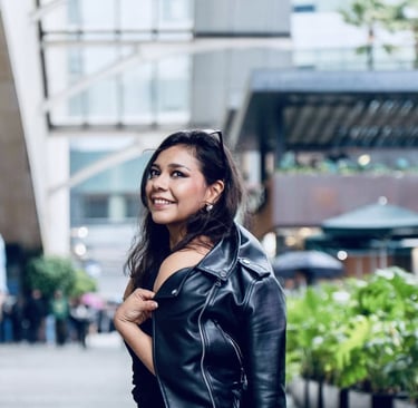 Mujer morena sonriente con chamarra de piel negra.