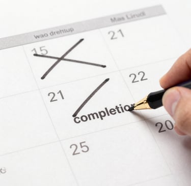 Hand writing completion on a paper calendar with a fountain pen to mark a project deadline.