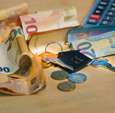 House keys on Euro banknotes and coins with a calculator for mortgage and real estate financing.