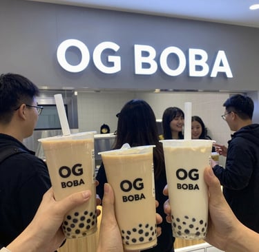 A colorful lineup of boba drinks showcasing fresh fruit toppings and vibrant layers under soft café lighting.
