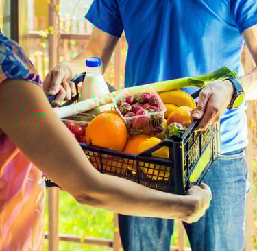 a man and woman holding a basket of fruit