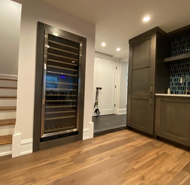 Professional basement finishing with modern flooring, and build in wine cooler refrigerator