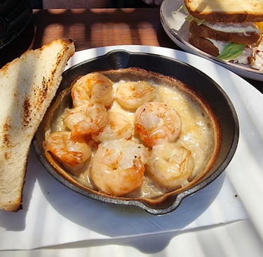 Sizzling garlic butter shrimp in a cast iron skillet served with toasted sourdough bread.