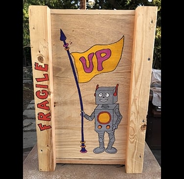 Shipping crate for Talbotics sculpture with image of rocketship drawn on it.