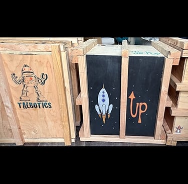 Shipping crate for Talbotics sculpture with image of rocketship drawn on it.