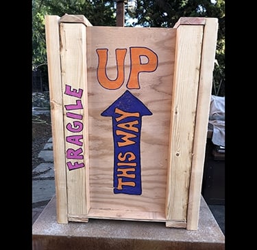 Shipping crate for Talbotics sculpture with image of arrow pointing up drawn on it.