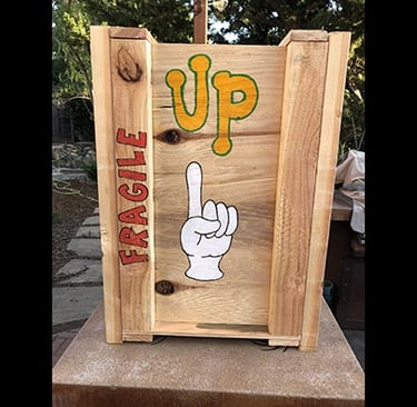 Shipping crate for Talbotics sculpture with image of hand pointing up drawn on it.