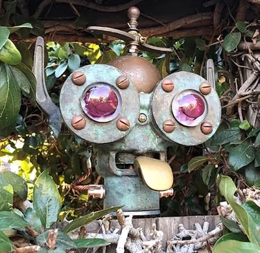 Robot head in hedge sticking out his tonguel