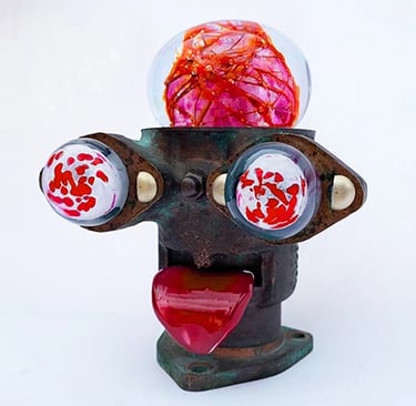 Assemblage robot head with red glass brain, bloodshot eyes and tongue sticking out.