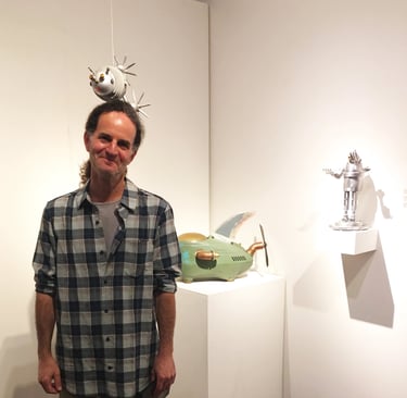 Photo of artist Tal Avitzur at a gallery showing of his art.