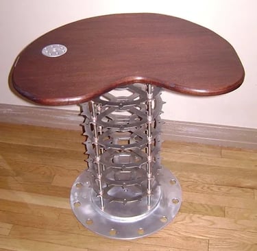 Coffee table with wood top and aluminum body made of gears.