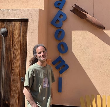Artist Tal Avitzur next to KABOOM! sign.