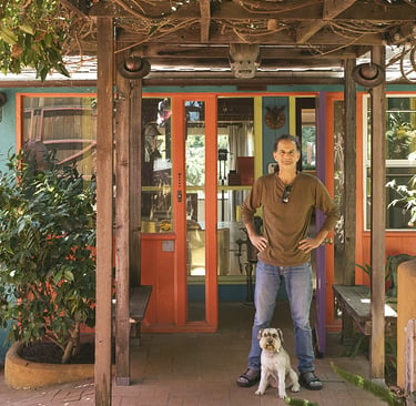 Artist Tal Avitzur with canine friend Milo at entrance to home gallery.