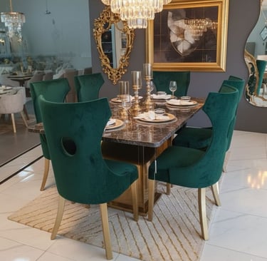Luxury dining room set featuring emerald green velvet chairs and a marble table under a crystal chandelier.