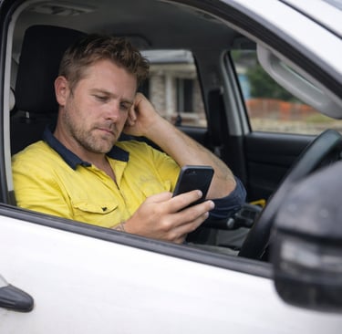 Tradie using ServiceM8 job management in work ute