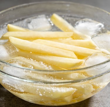 batata fatiadas em um recipiente com agua e gelo