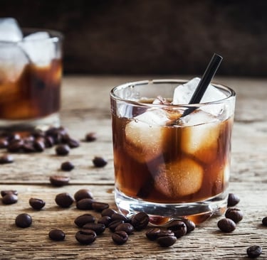 copo com bebida de cafe em cima de uma base de madeira com grãos de cafe