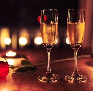 two champagne glasses with a rose on a table
