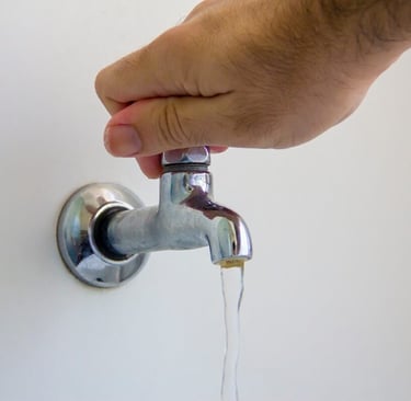 mão fechando torneira d'agua