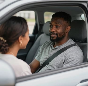 A cheerful young man sitting at a desk using a laptop to book a health screening appointment.
