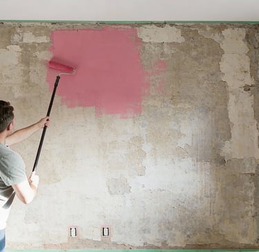 a man is painting a wall with a roller brush