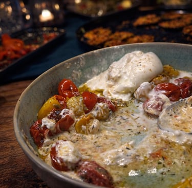 Fresh burrata cheese with roasted cherry tomatoes and balsamic glaze in a ceramic serving bowl.