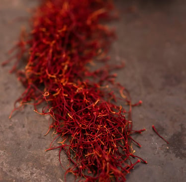 Red saffron threads spilled on a rustic surface for gourmet cooking and spice seasoning.