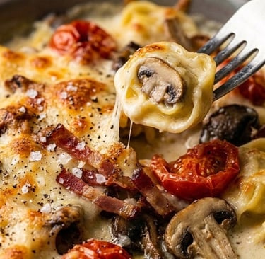 Baked cheese tortellini with mushrooms, crispy bacon, and roasted tomatoes in a creamy sauce.