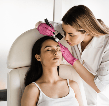 Dermatologist performing a facial skin examination using a dermatoscope during skin cancer screening