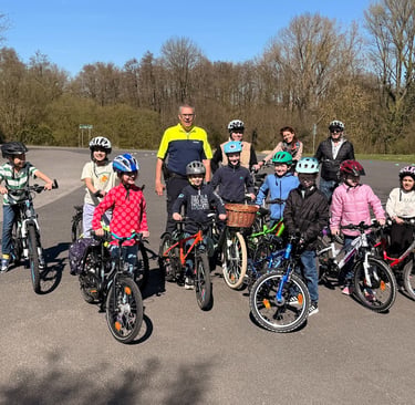 Gruppe von Kindern mit Fahrrädern und Helmen beim Fahrradtraining von Niederkrüchten hilft