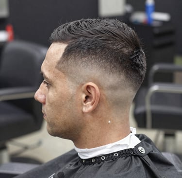 A client relaxing while receiving a detailed eyebrow shave with a straight razor.