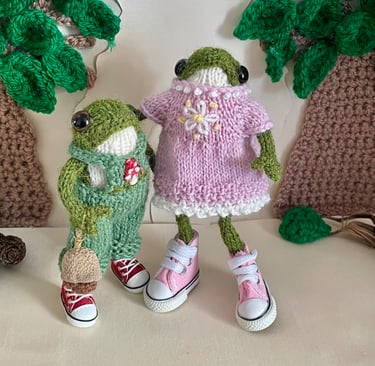 a couple of knitted frogs in a row of knitted toys