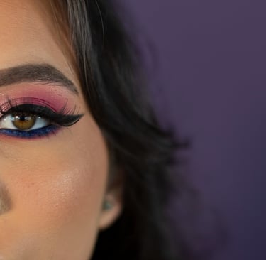 Primer plano del ojo de una mujer con sombra de ojos con brillo rosa y morado, delineador de ojos 
