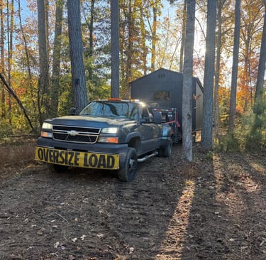 Shed on a trailer in the woods being delivered