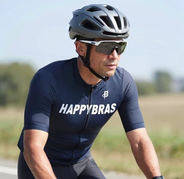 Urban cyclist riding through a vibrant city street wearing happybras gear