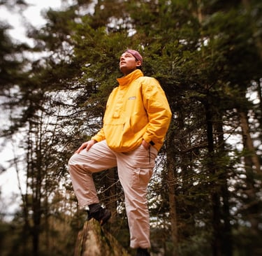 Homme sur un rocher qui regarde vers le ciel dans une forêt