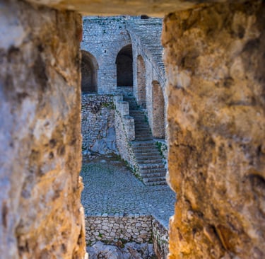 Ancient Palamidi Fortress stone stairs and arches in Nafplio Greece viewed through a window.