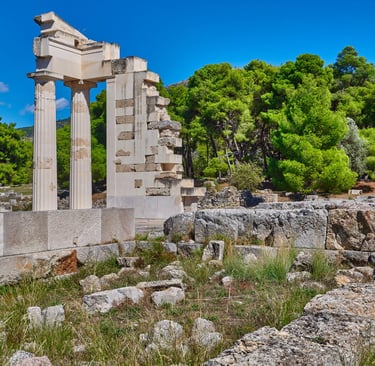 Ancient ruins of the Sanctuary of Asclepius at Epidaurus with stone columns and lush green trees.