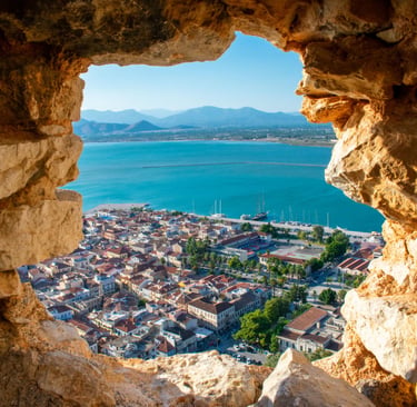 Scenic view of Nafplio city and Argolic Gulf through a stone window at Palamidi Fortress in Greece.